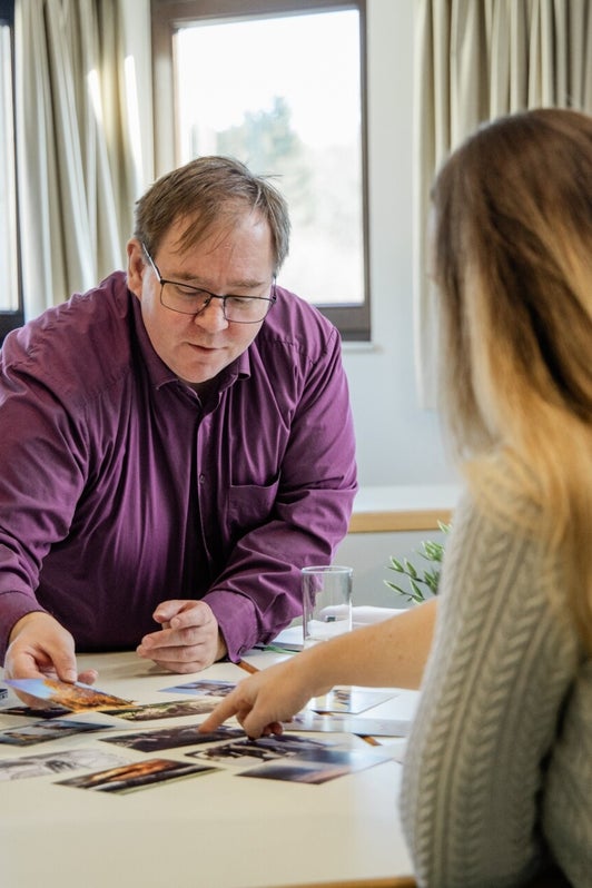 Ronald Neumayer sortiert Arbeitsmaterial im persönlichen Coachinggespräch
