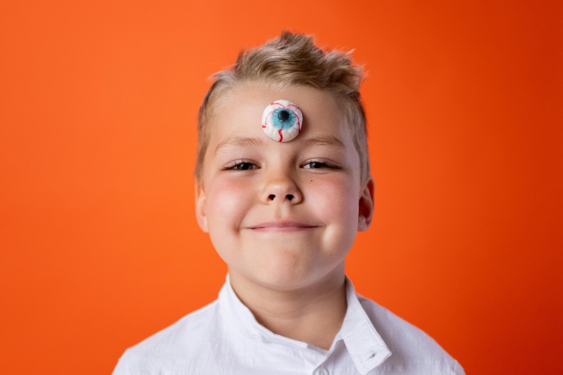 Photorealistic image of a boy with a large, surreal eyeball on his forehead, symbolizing third eye activation and heightened perception.