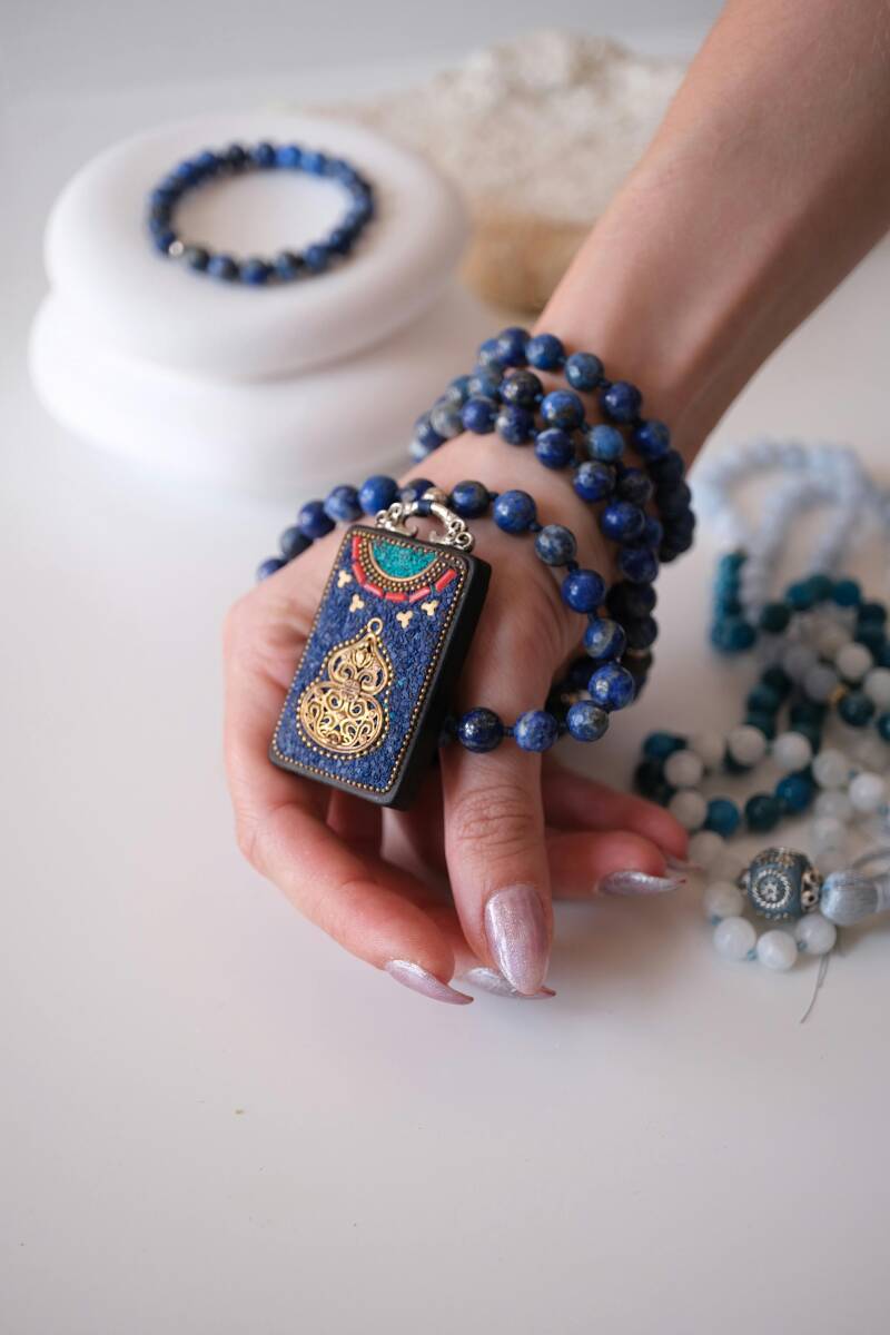 Hand adorned with lapis lazuli bead bracelet, symbolizing intuition, spiritual awakening, and third eye activation.