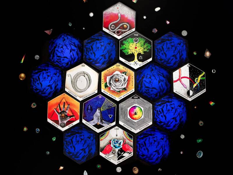 The Wild Unknown Alchemy Deck and Guidebook with cards spread out on a surface.