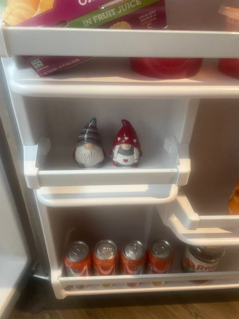 A gnome salt & pepper shaker, on the door inside a fridge, along with other refrigerator items