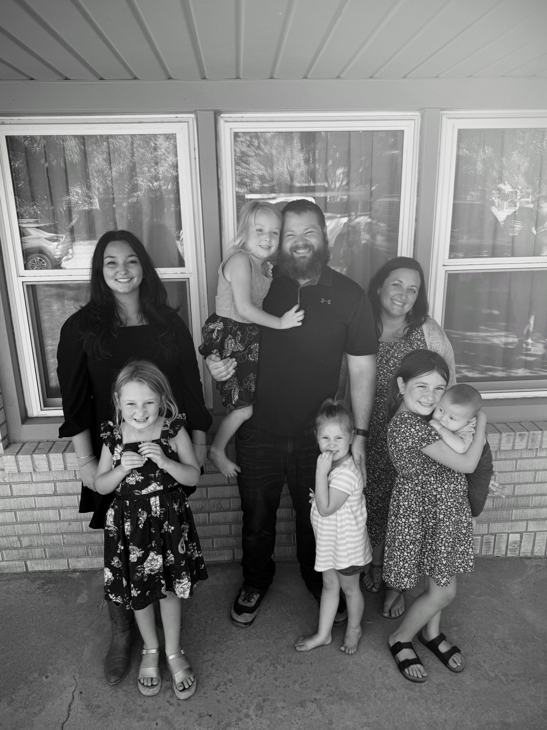 “Megan, Christian doula and childbirth educator at The Motherhood Calling, smiling with her husband and six children — sharing her faith-filled family life and passion for natural birth and virtual doula support.