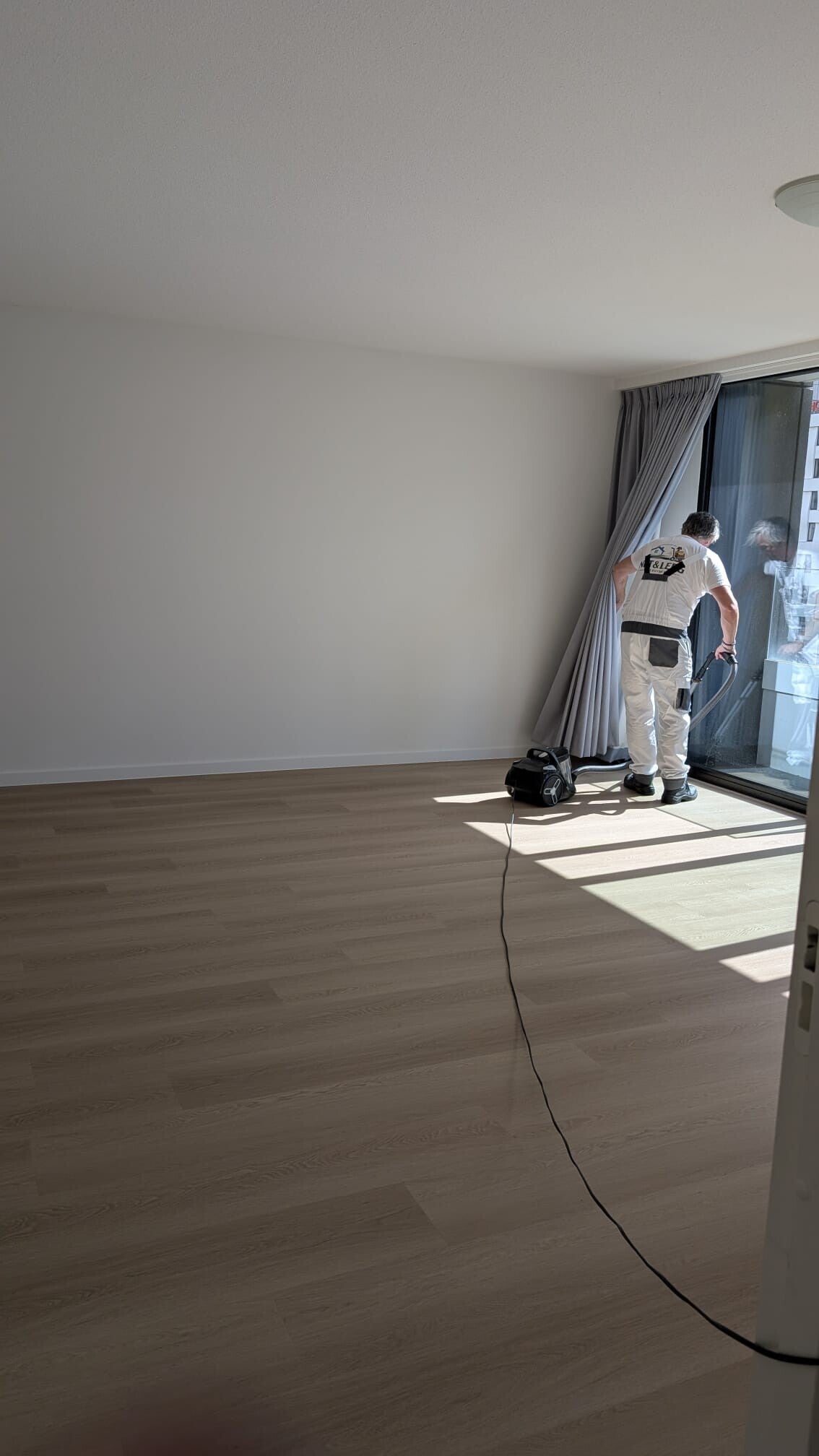 Medewerker stofzuigt de lege woning na de ontruiming