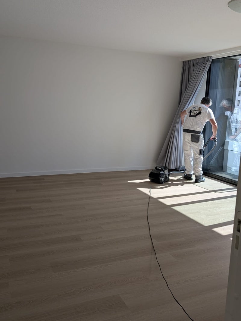 Medewerker stofzuigt de lege woning na de ontruiming