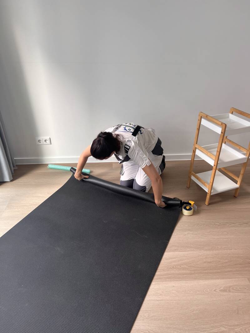 Medewerker van Net & Leeg rolt een mat op tijdens een woningontruiming