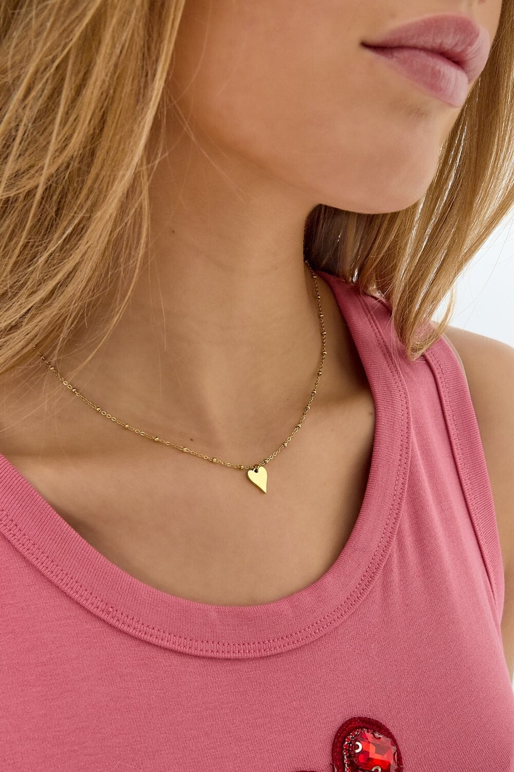 Halsketting met balletjes en hartje als bedeltje.