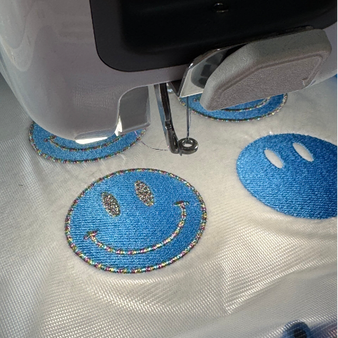 Borduurwerk blauwe smileys voorbeeld van gepersonaliseerde groepsborduring op kleding