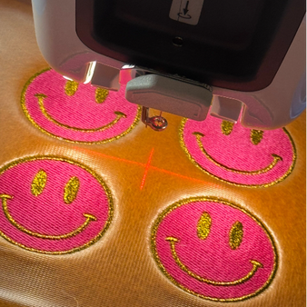 Borduurmachine aan het werk met kleurrijke smileys elk ontwerp begint hier met aandacht en precisie