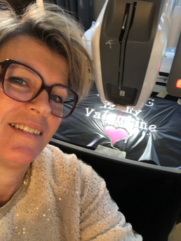 Sandra van Borduurstudio Sandra, met een glimlach achter haar borduurmachine