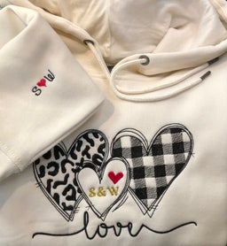 Hoodie geborduurd met een afbeelding met harjtes en de mouw voorzien van initialen geborduurd door Borduurstudio Sandra
