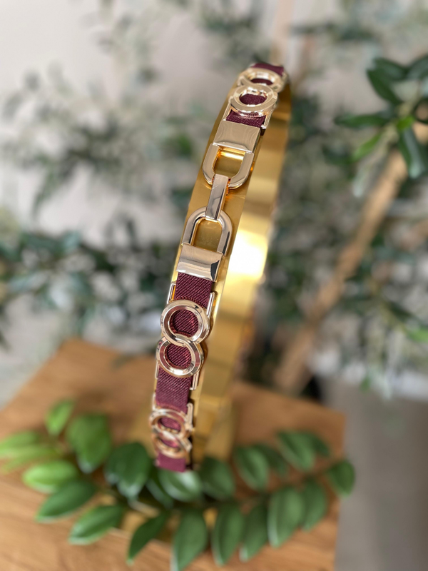 Elastische riem bordeaux met goud detail.