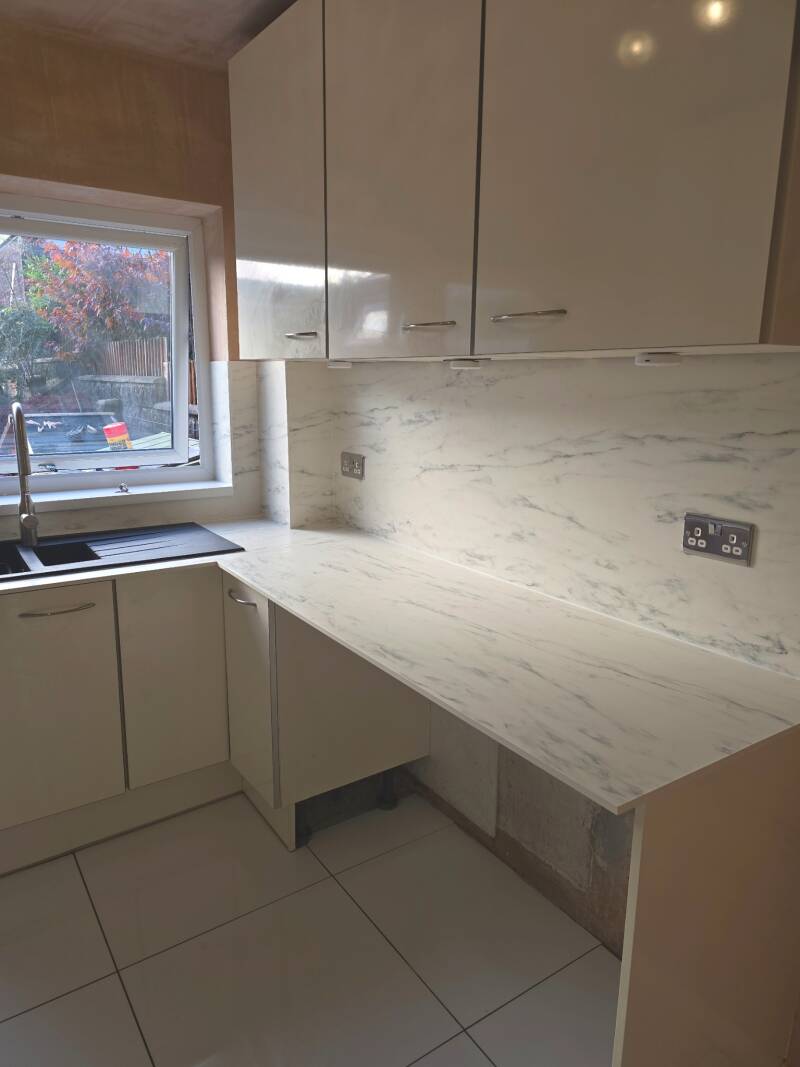 Newly fitted kitchen in Cardiff with under-cabinet lighting and white marble-effect worktops
