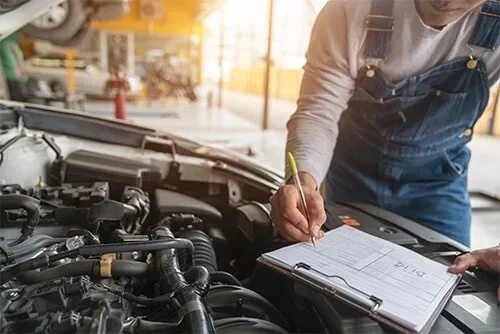 Mechanic performing a pre-purchase car inspection in Brisbane, checking a car's engine in a garage, serving Gold Coast.