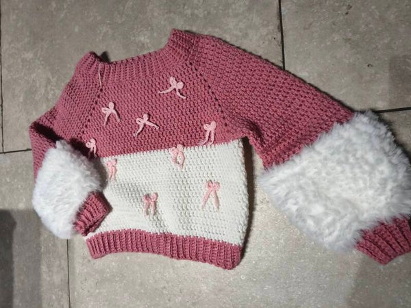 Trui gehaakt roze met strikjes witte pofmouwen