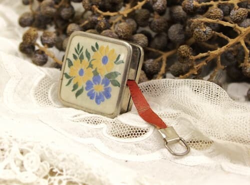 Vintage uitrolbare meetlint met geborduurd bloemen decor op de bovenkant