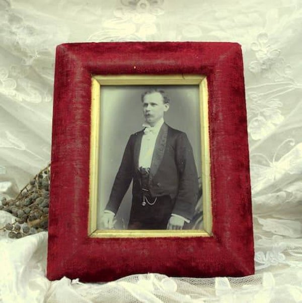 Oude foto van heer in smoking in rood fluwelen fotolijst