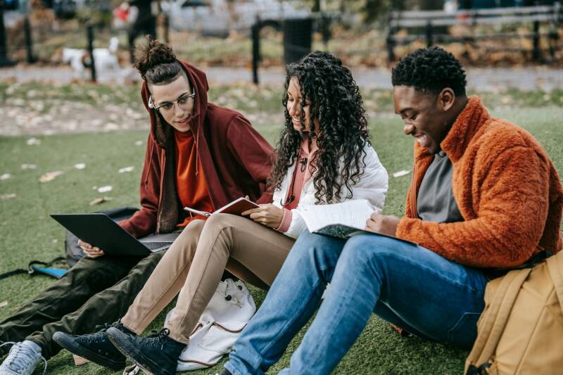 College students relaxing together outdoors, illustrating friendship and wellbeing