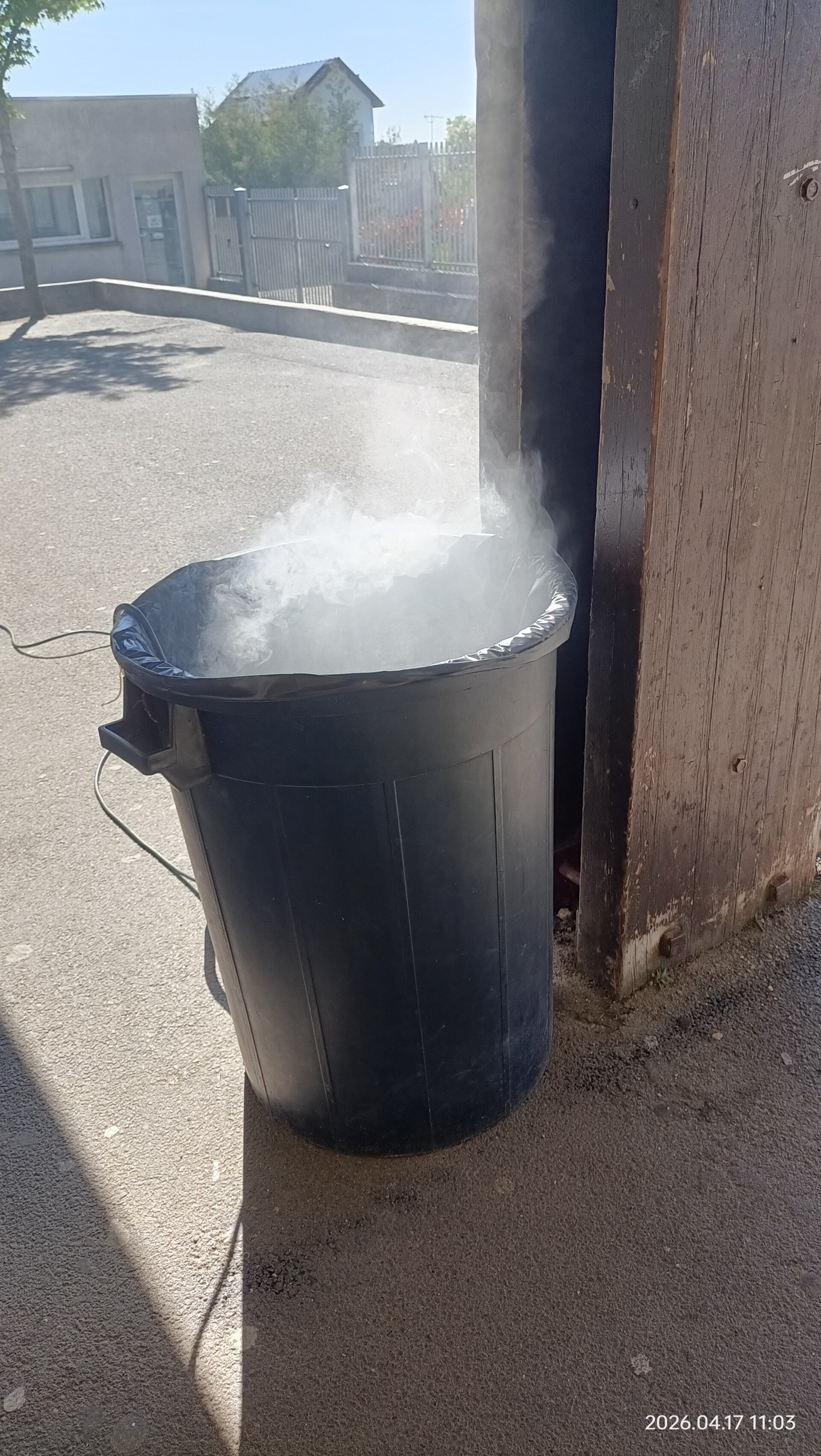 Fumée s'échappant d'une poubelle métallique, exercice pratique d'extinction incendie