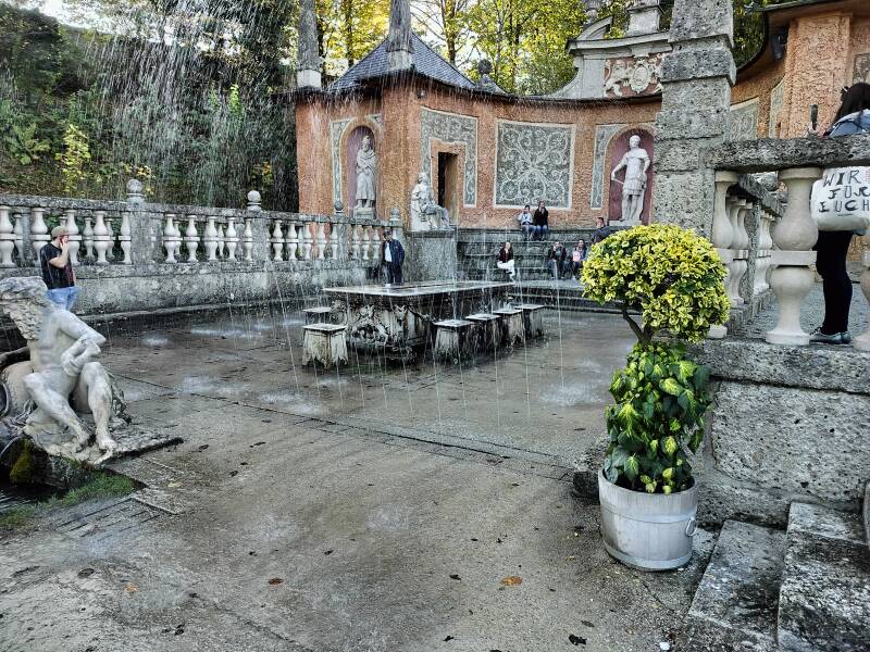 Visitors surprised by the water jets at the Trick Fountains in Hellbrunn Palace, Salzburg.