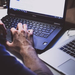 Foto van een man die typt op een laptop