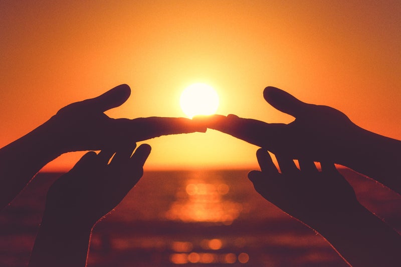 Genieten: handen en zonsondergang