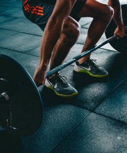 Patient lifting weights in the gym to reduce injury risk in Frome, Warminster or Bath