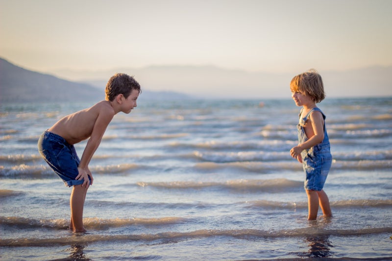 Kinder spielen am Strand