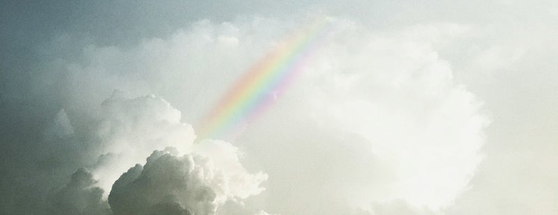 Dark clouds with a rainbow heading to the light to represent therapy and change