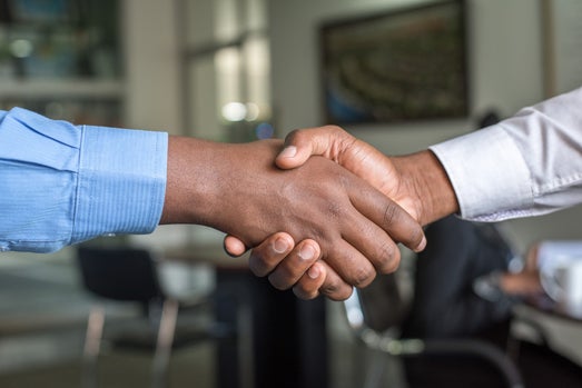 Handshake making a deal, symbolizing the partnership and trust between a small business owner and a professional bookkeeper. Represents the importance of reliable bookkeeping services for business success.