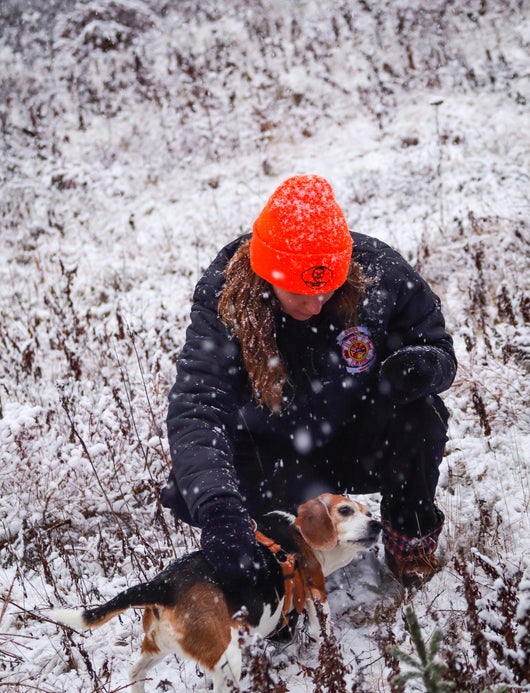 Die Hundeführerin mit ihrem Beagle bei Schneefall