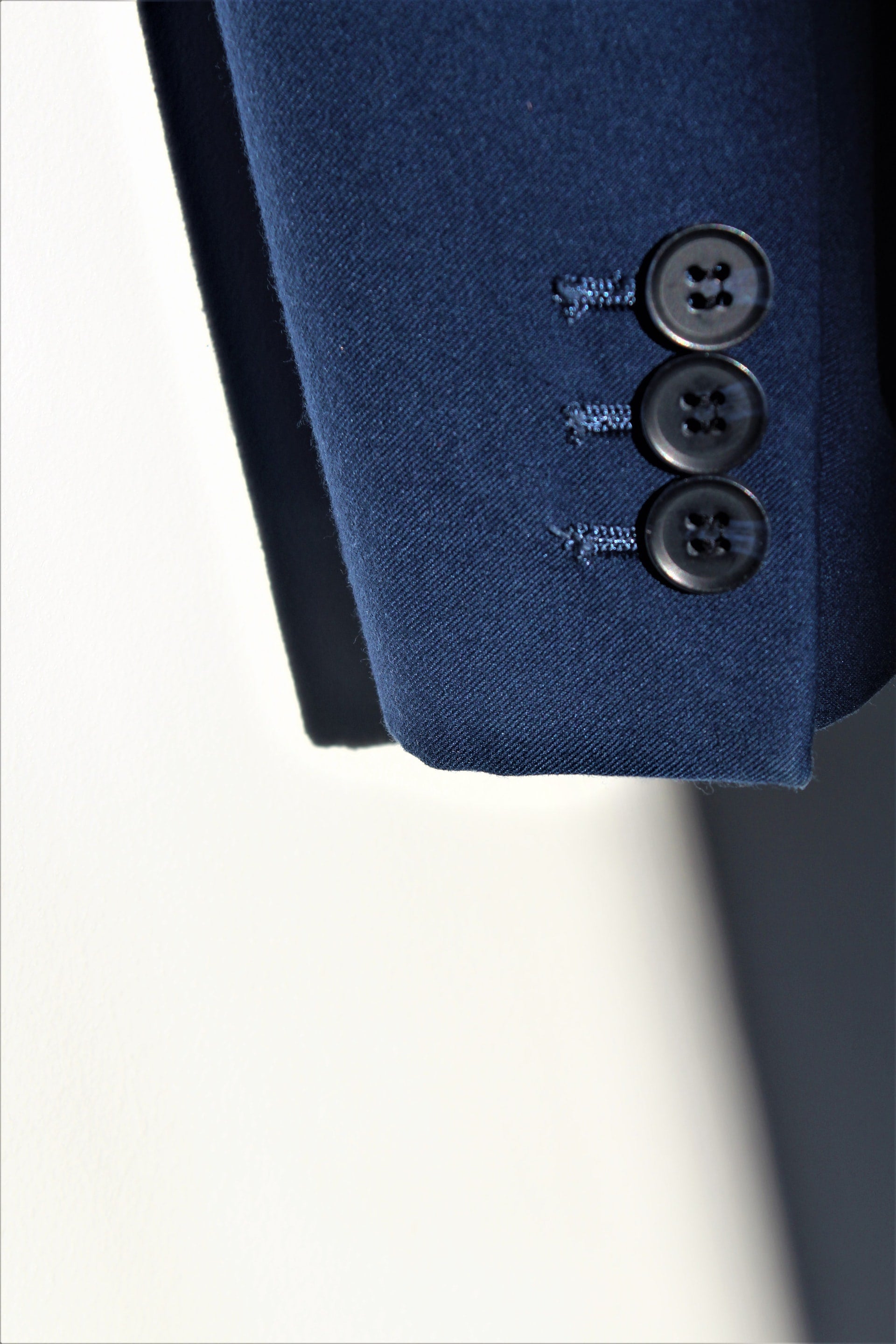 Gros plan sur une sélection de tissus haut de gamme pour le prêt-à-porter masculin, incluant des laines texturées, des cotons et des mélanges innovants, représentant l'expertise d'un styliste freelance pour la conception de collections masculines.