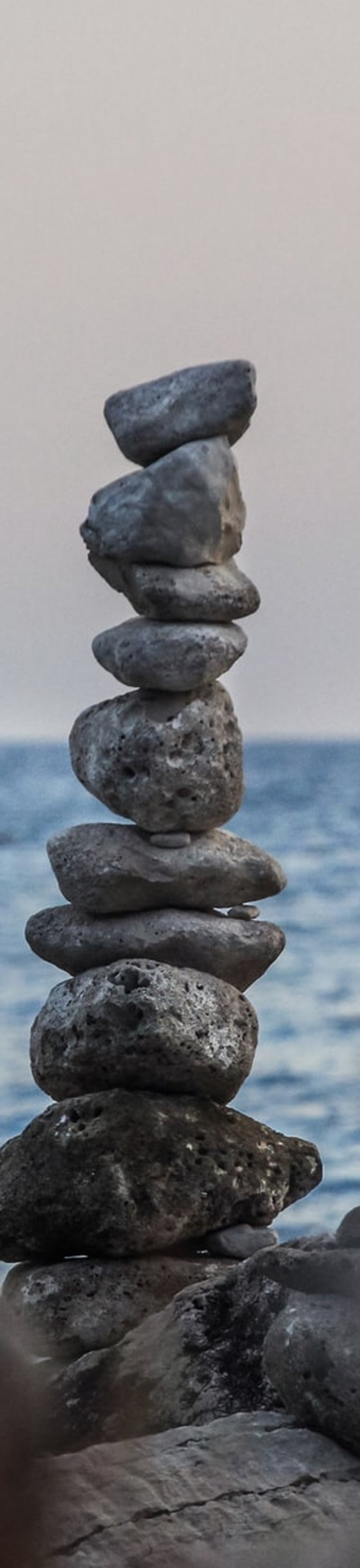 Auf diesenbild sind an einem Strand Steine übereinandergestapelt.