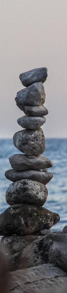 Auf diesenbild sind an einem Strand Steine übereinandergestapelt.