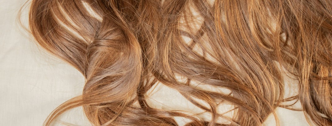 Light brown long hair on a light background.